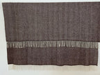 Dark Brown herringbone woven blanket with white fringe on a white background