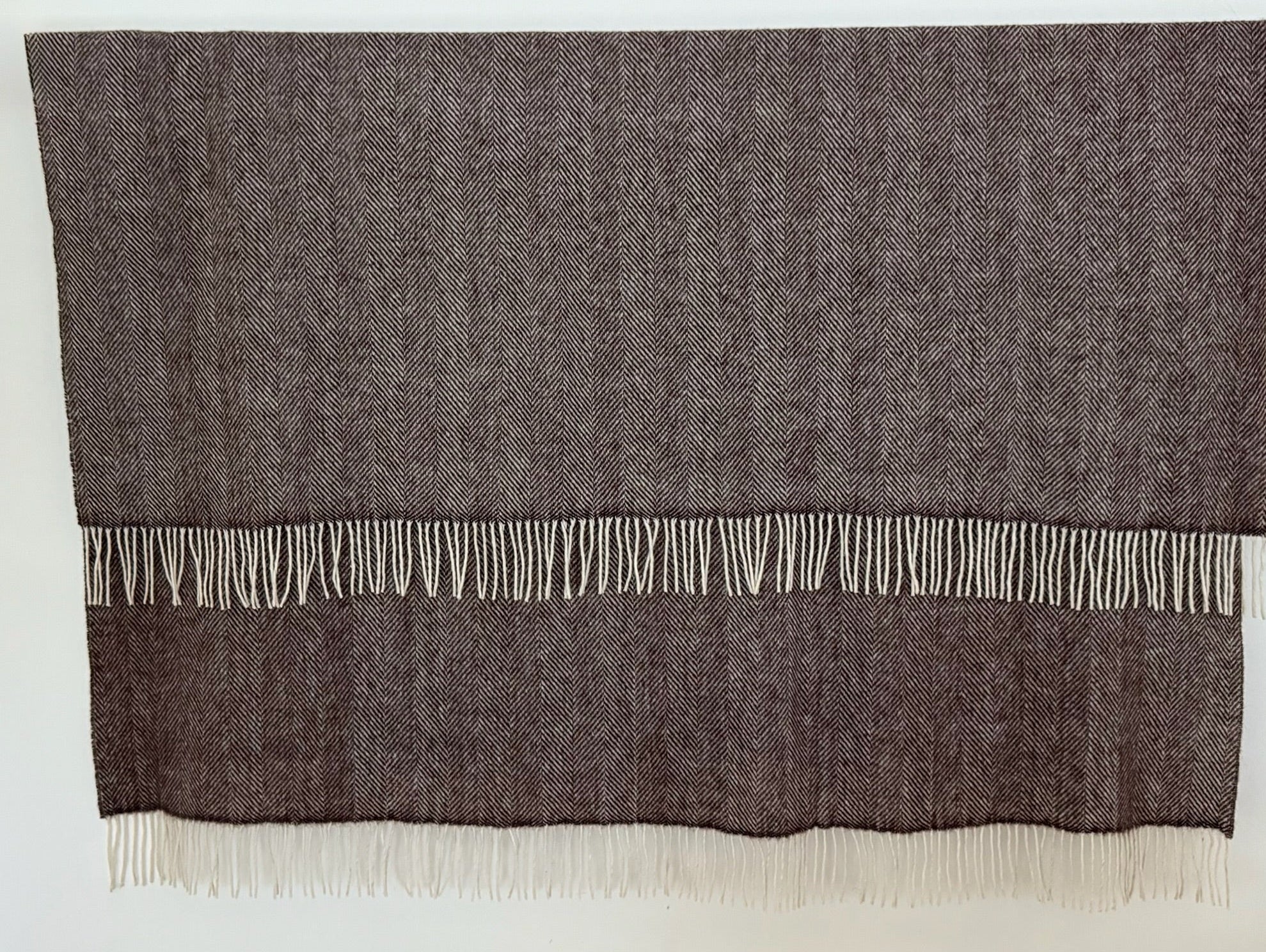 Dark Brown herringbone woven blanket with white fringe on a white background
